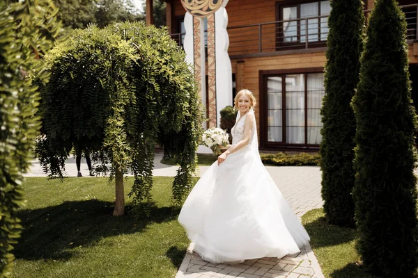 Νύφη Ένα Φόρεμα Στέκεται Ένα Καταπράσινο Κήπο Και Κρατώντας Ένα — Φωτογραφία Αρχείου