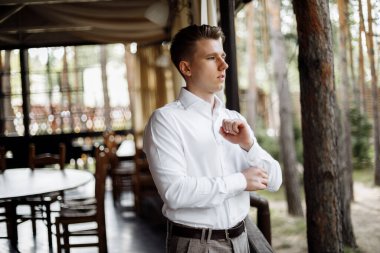 Mutlu yakışıklı damat sabah giyiniyor. Damat düğün hazırlıkları için bir takım elbise giyer. Yüksek kalite fotoğraf