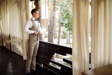 Mutlu yakışıklı damat sabah giyiniyor. Damat düğün hazırlıkları için bir takım elbise giyer. Yüksek kalite fotoğraf