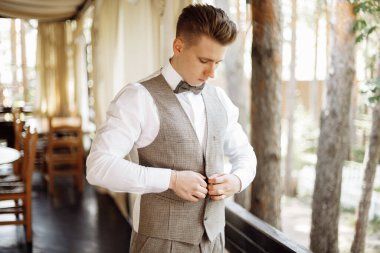 Mutlu yakışıklı damat sabah giyiniyor. Damat düğün hazırlıkları için bir takım elbise giyer. Yüksek kalite fotoğraf