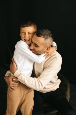 Siyah arka planda oğlu olan baba, babasının sevgisi. Yüksek kalite fotoğraf