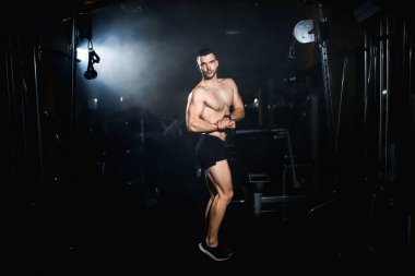 Kaslı atlet kaslarını, gövdesini, trisepslerini ve göğüs kaslarını gösteriyor. Yüksek kalite fotoğraf