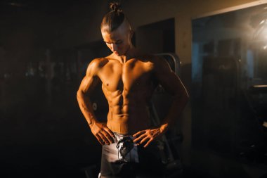 Spor salonundaki genç bir atletin silueti, yakışıklı bir adamın gövdesi. - Evet. Yüksek kalite fotoğraf