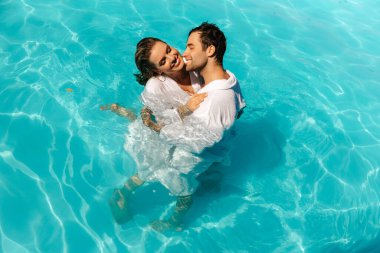 Havuzda genç, seksi ve çekici bir çift öpüşüyor. Yüksek kalite fotoğraf