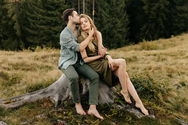 Sevgi dolu genç bir çift dağların arka planında birbirine sarılıyor. Yüksek kalite fotoğraf