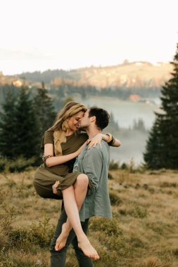 Genç mutlu çift dağlarda eğleniyor. Yüksek kalite fotoğraf