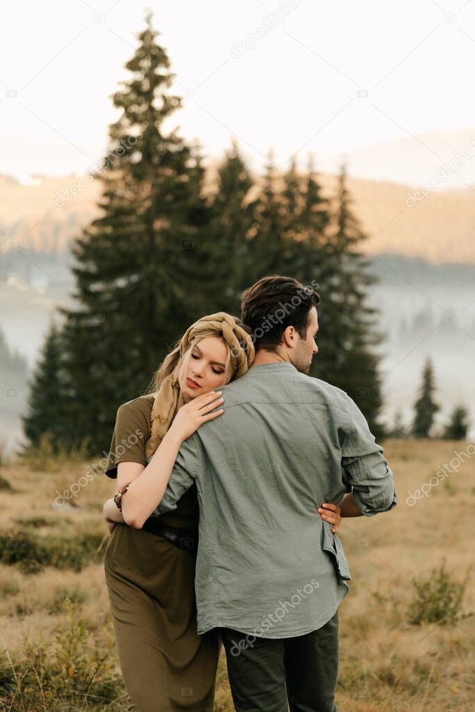 Young happy couple in love hugging smiling and having fun in the mountains. High quality photo