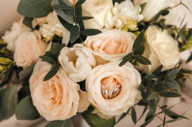 Alyanslar, yeni evlilerin düğün çiçekleri, bej gül yüzükler. Yüksek kalite fotoğraf