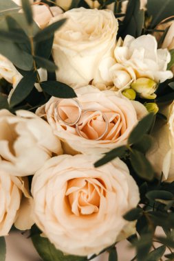 Alyanslar, yeni evlilerin düğün çiçekleri, bej gül yüzükler. Yüksek kalite fotoğraf