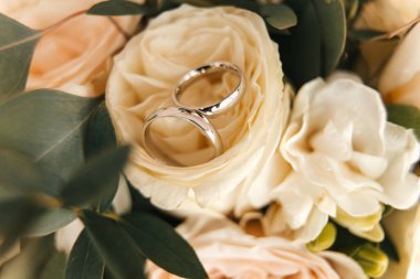 Alyanslar, yeni evlilerin düğün çiçekleri, bej gül yüzükler. Yüksek kalite fotoğraf