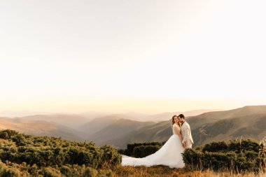Güzel bir çiftin arka planında birbirine aşık güzel bir çiftin dağlarda kucaklaşması. Yüksek kalite fotoğraf