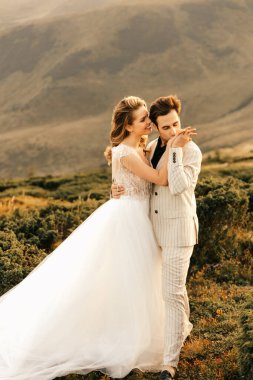 Güzel, mutlu, mutlu, birbirine aşık genç bir çift, dağlarda sarılıyor, arka planda güzel bir düğün çifti. Yüksek kalite fotoğraf