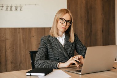 Dizüstü bilgisayarla çalışan genç ve güzel bir kadın. Konsantre ve ciddi, sorumluluk sahibi bir ofis çalışanı..