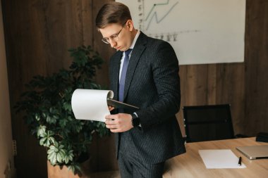 Gözlüklü bir işadamı ofiste belgeleri inceliyor. Yüksek kalite fotoğraf