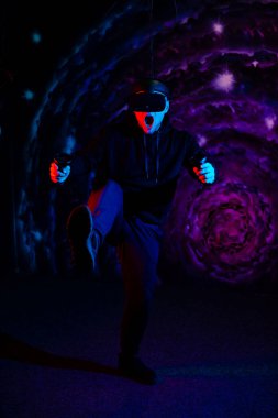 Oyun odasında sanal gerçeklik gözlüğü takan genç adam. VR 