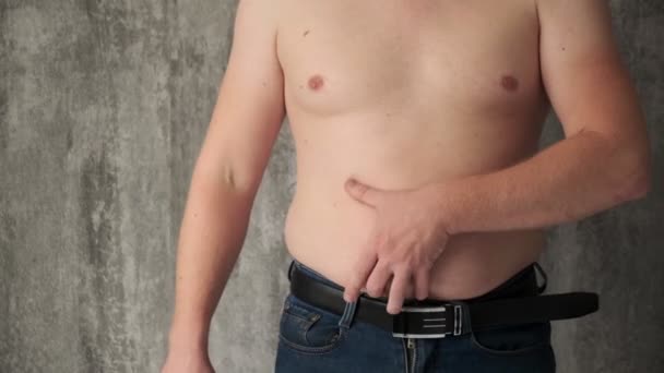 Le concept de se débarrasser de l'excès de poids.fat homme coupe les dépôts de graisse avec un couteau ventre. — Video