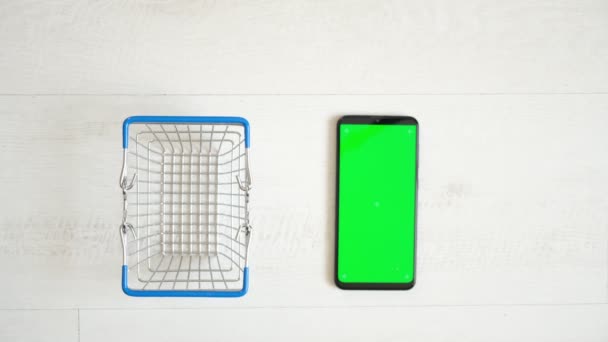 Telefone com tela verde na mesa com notebook e bolsa vista de cima, espaço de cópia de tela de cromo smartphone — Vídeo de Stock