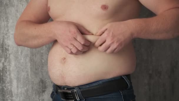 Close-up dikke man raakt de buik doen massage schudden. Hij is erg dik en heeft last van buikpijn omdat hij te veel eet. Een man masseert zijn maag. bestrijding van overgewicht — Stockvideo