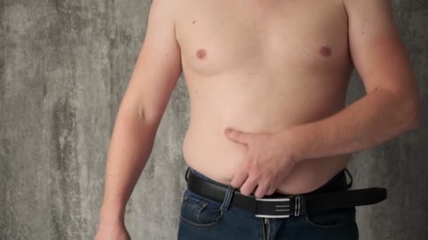 The concept of getting rid of excess weight.fat man cuts off fat deposits with belly knife. — Stock Video