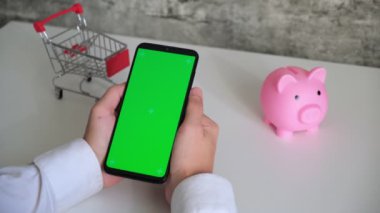 Yeşil ekranlı telefon, domuzcuk bankasının ödeme makbuzları, beyaz arkaplanlı vergi belgeleri. Akıllı telefon kromakey farklı yönlere kayar. Boşluğu kopyala