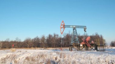 Petrol pompası sondaj kulesi ya da mavi kış gökyüzüne karşı sallanma makinesi. Soğuk, sert kış ve bol kar. Rusya ve Norveç 'te petrol endüstrisi. ham petrol fiyatları kavramı.