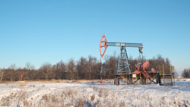 Wiertarka z pompą olejową lub maszyna do kołysania przed błękitnym zimowym niebem. Zimna, ostra zima i dużo śniegu. Przemysł naftowy w Rosji i Norwegii. Koncepcja cen ropy naftowej. — Wideo stockowe