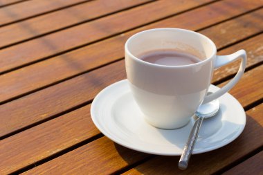 sıcak kahve ve ahşap arka plan üzerinde güneş