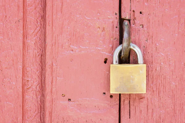 Nahaufnahme des Schlosses in der Mitte der blassroten Holztür — Stockfoto