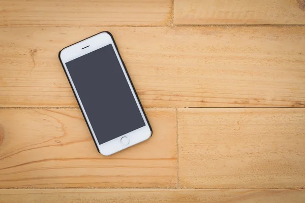 Smart phone sul tavolo superiore dello sfondo in legno . — Foto Stock