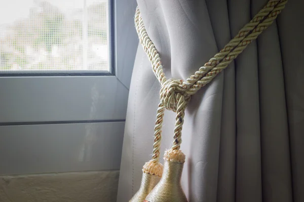 Primer plano cortinas borla con cuerda por la ventana a la izquierda —  Fotos de Stock