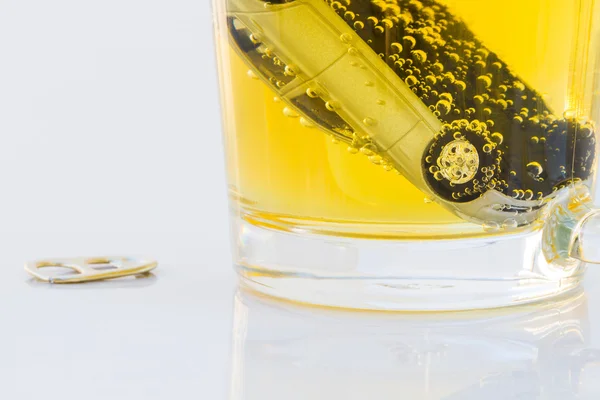 Horizontal photo of toy car in a glass of beer isolated on white — Stock Photo, Image