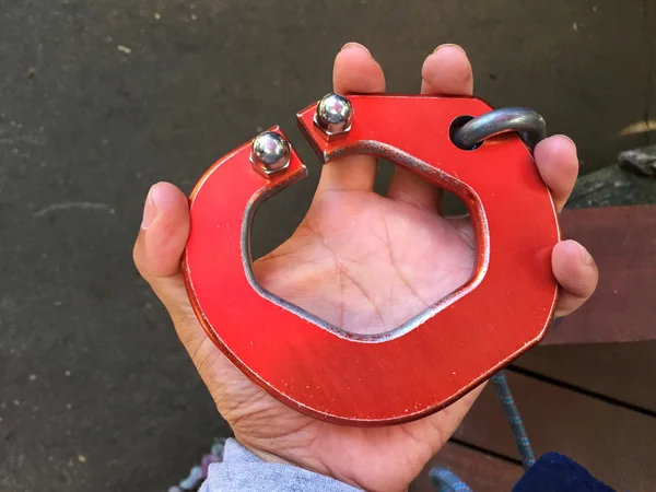 Horizontal photo of big red carabiner on man's left hand. — Stock Photo, Image