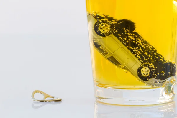 Horizontal photo of toy car in a glass of beer isolated on white — Stock Photo, Image