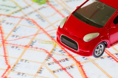 tatlı kırmızı araba oyuncak tablet ekranındaki harita üzerinde yatay fotoğraf.