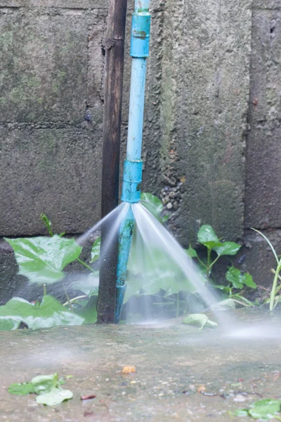 Oude roestige pvc pijp met lek en water spuiten uit — Stockfoto