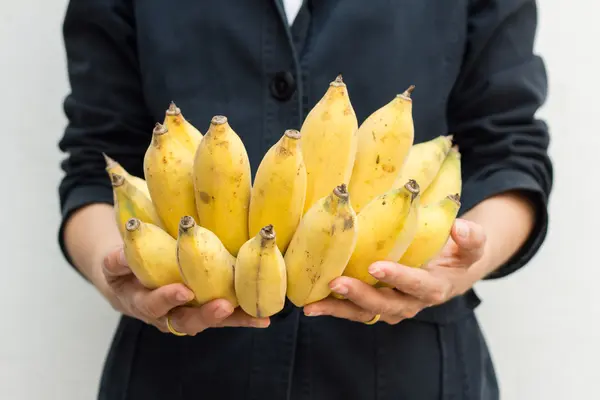 Zbliżenie na młoda kobieta gospodarstwa klastra bananów — Zdjęcie stockowe