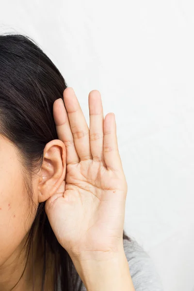 Mujer sostiene su mano cerca de su oído y escucha — Foto de Stock