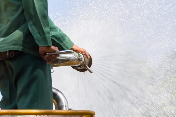 Plantas de riego hombre en camión de agua en el parque — Foto de Stock