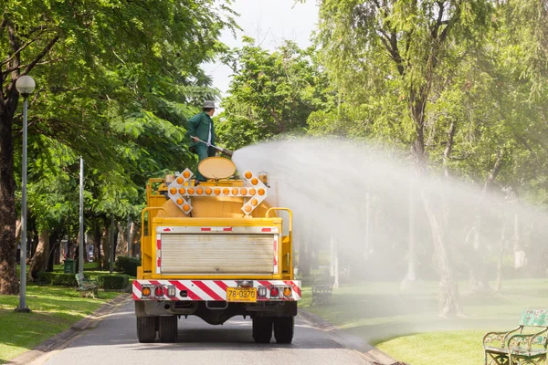 Mens op water truck in het park planten water geven — Stockfoto