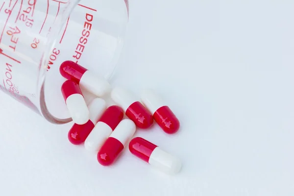 Groupe de médicament capsule rouge blanc en verre sur fond blanc — Photo