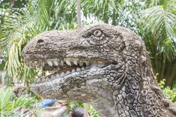 Hoofd van de dinosaurus beeldhouwkunst in openbaar park — Stockfoto