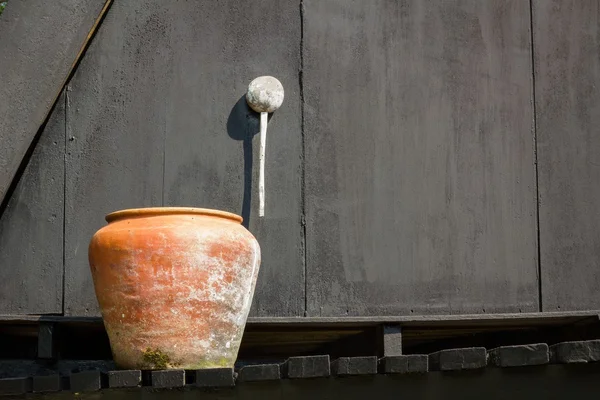 Orangefarbenes Wasser auf dem schwarzen Hintergrund der alten Holzwand — Stockfoto