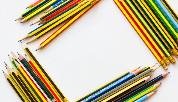 Colorful pencils on the white paper, view from above — Stock Photo, Image