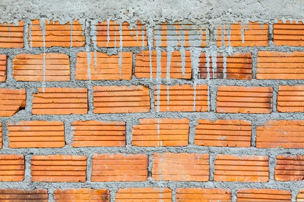 Closeup orange horizontal textured brick with dry concrete stain — Stock Photo, Image