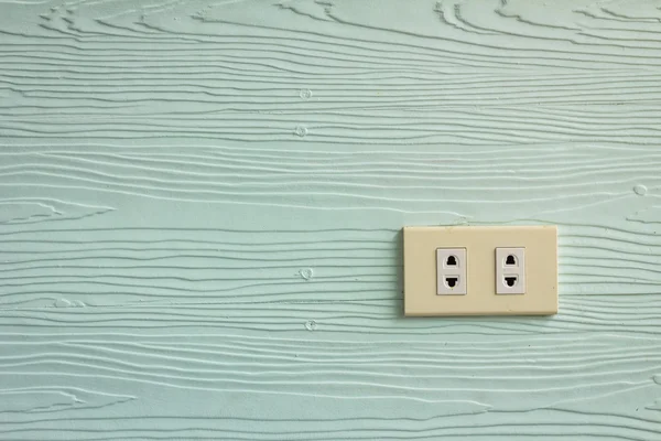 Enchufes de pared en la pared verde pálido con textura de madera — Foto de Stock