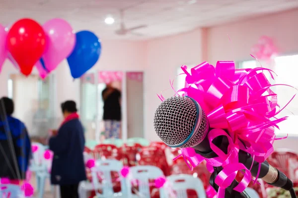 Microphone with pink bow and ribbon in wedding ceremony hall — Stock Photo, Image