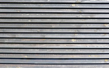 Duvarın ya da çitin bir parçası boylamında boylamsal olarak boyanmamış ahşap tahtalar. Soyut arkaplan. Doku.