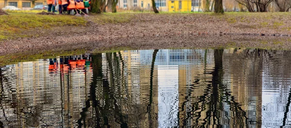 Cleaning autumn leaves2. Workers , raking leaves on  shore of po — Stock Photo, Image