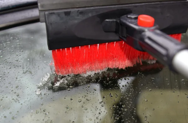 Part of the brush which is clearing away snow at a car window — Stock Photo, Image