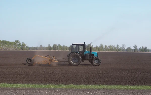 Traktör toprağı sürüyor.